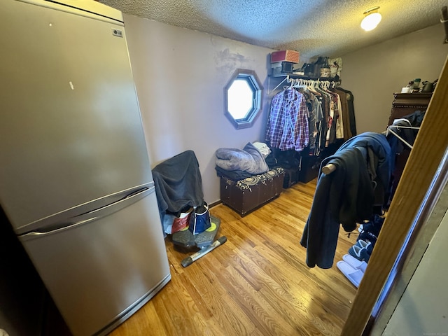 walk in closet with wood finished floors