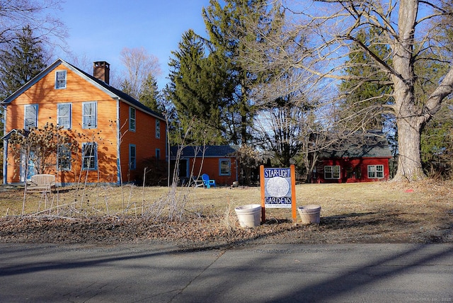 view of property exterior featuring an outbuilding and a chimney