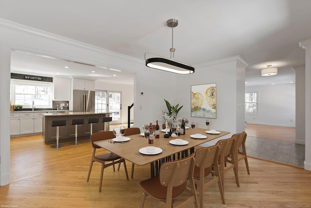 dining space featuring ornamental molding, recessed lighting, light wood-style flooring, and baseboards