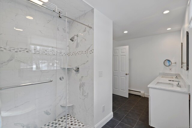 bathroom with tile patterned flooring, baseboards, baseboard heating, a marble finish shower, and double vanity