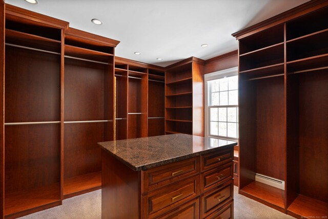 walk in closet featuring a baseboard heating unit and light carpet