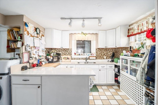 kitchen featuring white cabinets, light countertops, and a sink