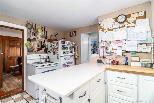 kitchen with a peninsula, white appliances, white cabinetry, and light countertops