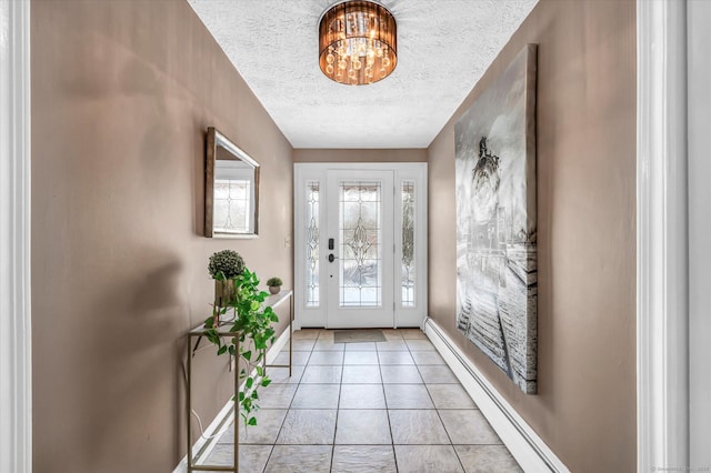 foyer featuring a textured ceiling, light tile patterned floors, a baseboard radiator, and an inviting chandelier