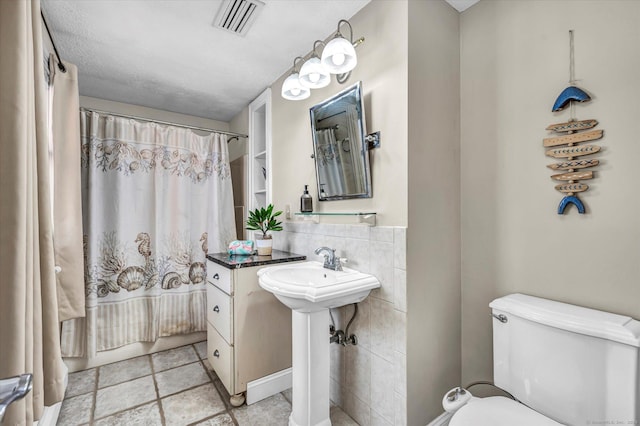 full bathroom with toilet and visible vents