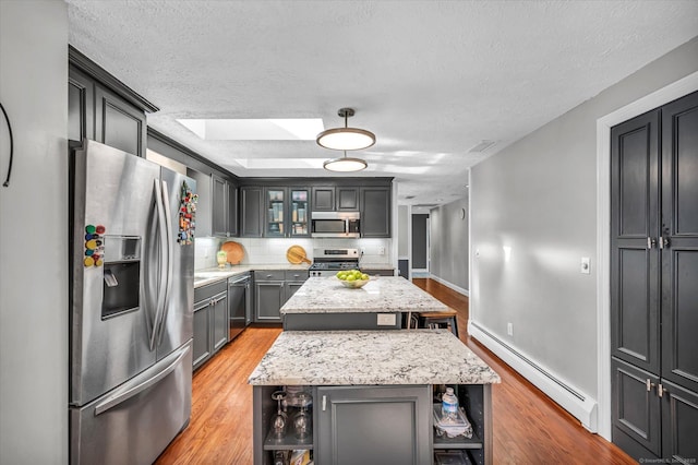 kitchen featuring a baseboard radiator, light wood-style flooring, appliances with stainless steel finishes, a center island, and open shelves