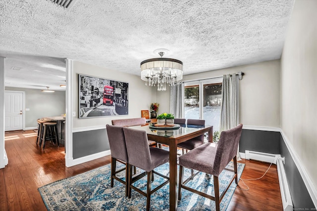 dining space featuring a baseboard radiator, a notable chandelier, visible vents, baseboards, and hardwood / wood-style floors