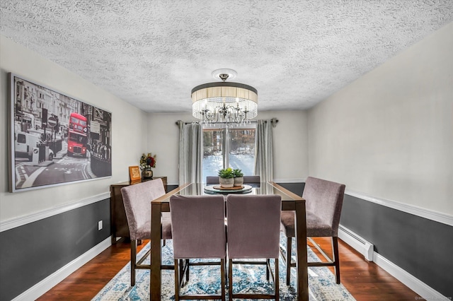 dining area with a baseboard heating unit, a chandelier, baseboards, and dark wood-style floors