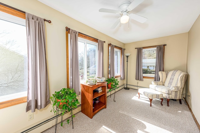 sitting room with a ceiling fan, a baseboard radiator, and carpet floors