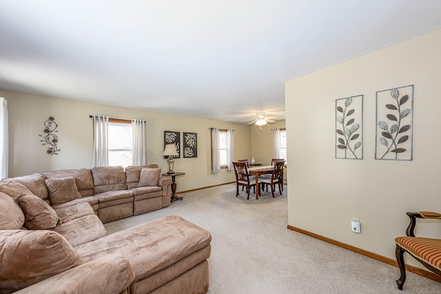 living room featuring plenty of natural light, baseboards, and light colored carpet