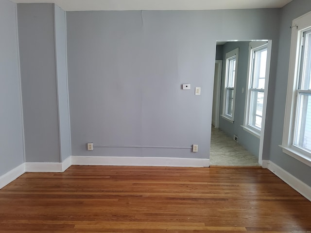 unfurnished room featuring baseboards and wood finished floors