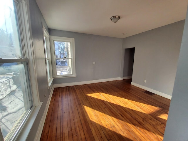 unfurnished room with hardwood / wood-style floors and baseboards