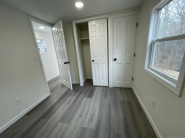 unfurnished bedroom with baseboards, wood finished floors, and recessed lighting