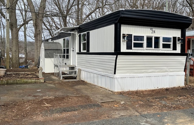 view of property exterior featuring a storage shed and an outdoor structure