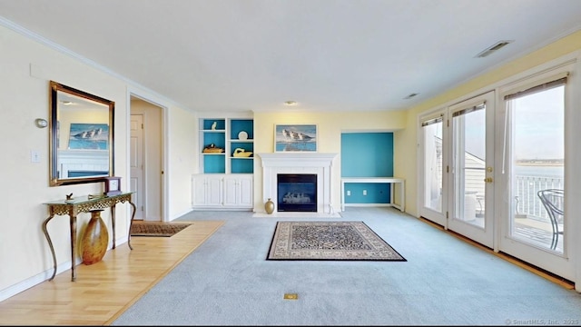 living room featuring a fireplace with flush hearth, visible vents, baseboards, and ornamental molding