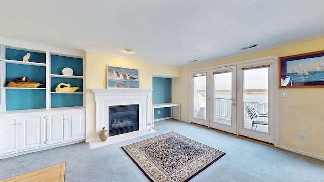 carpeted living room with french doors, visible vents, a tiled fireplace, ornamental molding, and baseboards