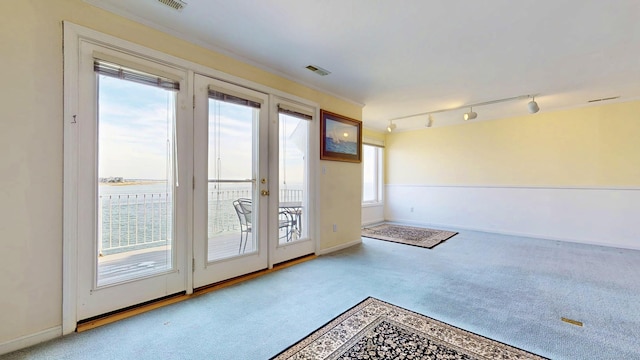 entryway with rail lighting, carpet, visible vents, and baseboards