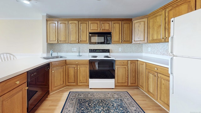 kitchen with light wood-style flooring, a sink, ornamental molding, black appliances, and tasteful backsplash