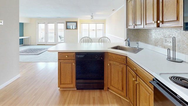 kitchen with light countertops, dishwasher, a peninsula, and a sink