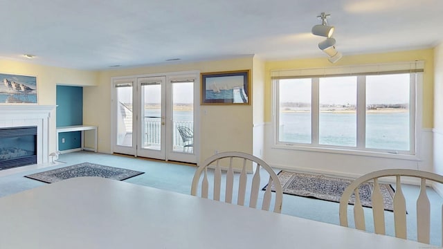 carpeted dining area featuring a fireplace with flush hearth