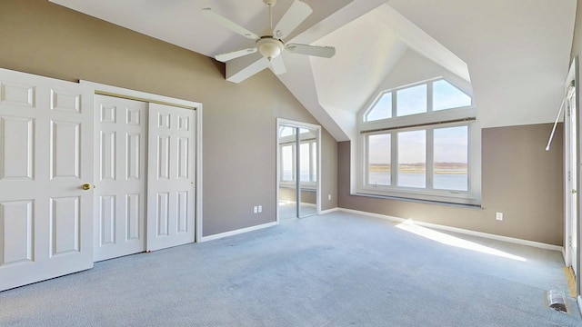 unfurnished bedroom featuring ceiling fan, high vaulted ceiling, carpet flooring, baseboards, and a closet