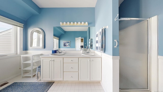 full bathroom featuring lofted ceiling, a sink, a shower stall, and tile patterned floors