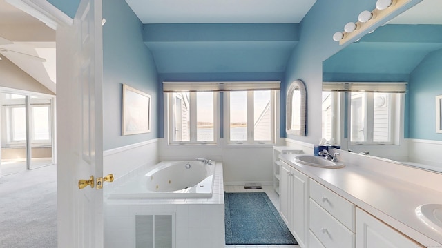 full bathroom featuring lofted ceiling, a sink, visible vents, a whirlpool tub, and double vanity