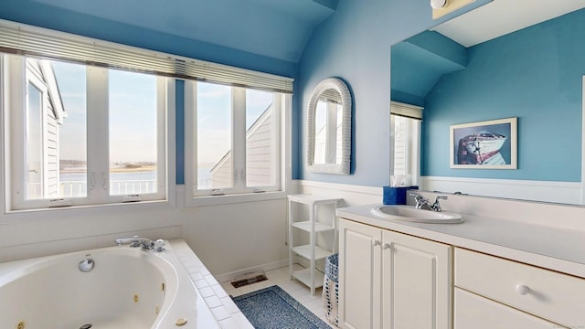 full bath featuring a whirlpool tub, tile patterned flooring, vaulted ceiling, and vanity