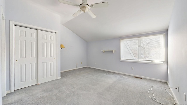 unfurnished bedroom with carpet, baseboards, vaulted ceiling, and a closet