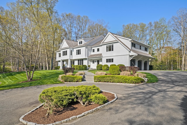 shingle-style home with aphalt driveway and an attached garage