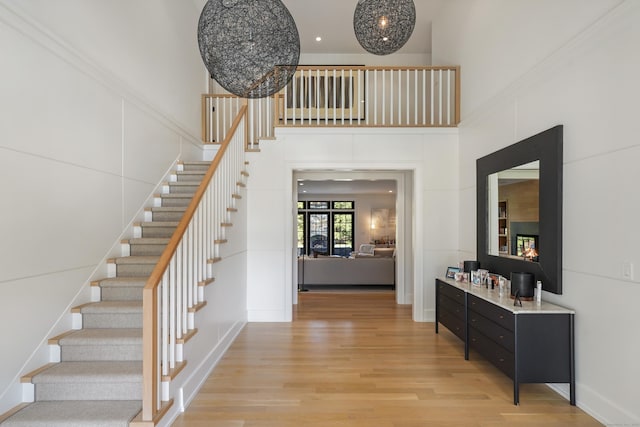 entryway with stairway, light wood-type flooring, and baseboards
