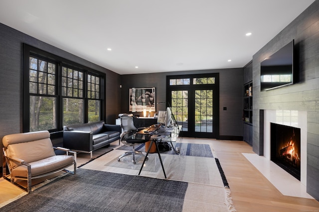 interior space featuring a fireplace, recessed lighting, an accent wall, and light wood-type flooring