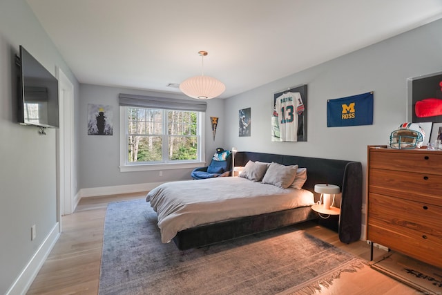 bedroom with baseboards and light wood finished floors