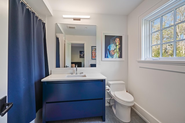 full bath with visible vents, toilet, vanity, and baseboards