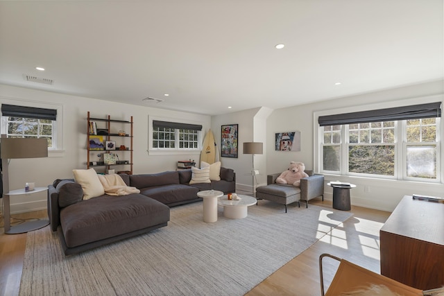 living room with recessed lighting, visible vents, light wood-style flooring, and a healthy amount of sunlight