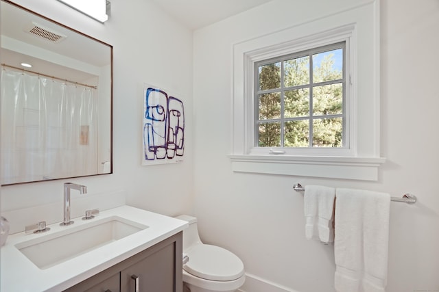full bath with vanity, toilet, and visible vents