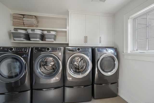 laundry area featuring baseboards, visible vents, cabinet space, and independent washer and dryer