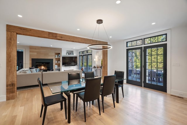 dining room with recessed lighting, a fireplace, light wood finished floors, baseboards, and visible vents
