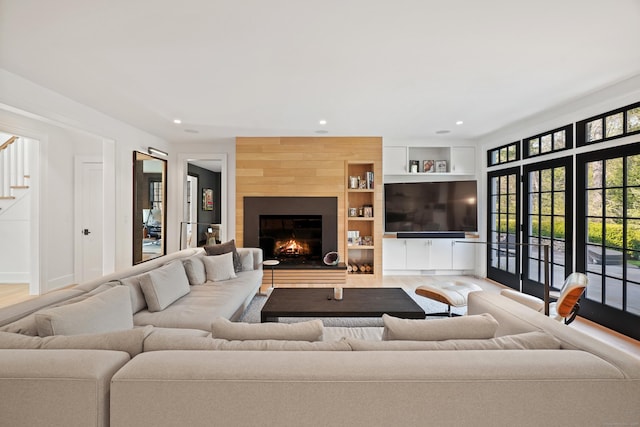 living room featuring recessed lighting, wood finished floors, stairs, and a fireplace