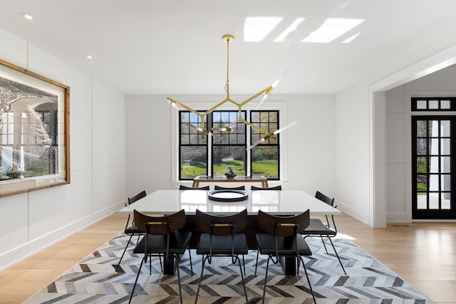 dining room featuring baseboards, light wood finished floors, recessed lighting, and a notable chandelier