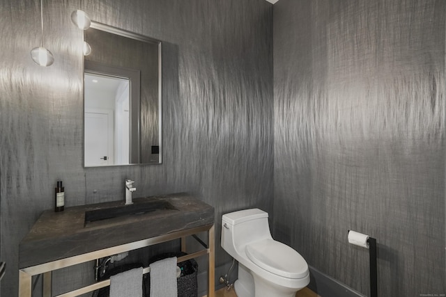 half bath featuring toilet and a sink