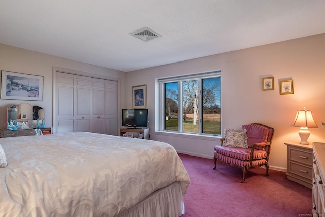 bedroom with a closet, carpet flooring, baseboards, and visible vents