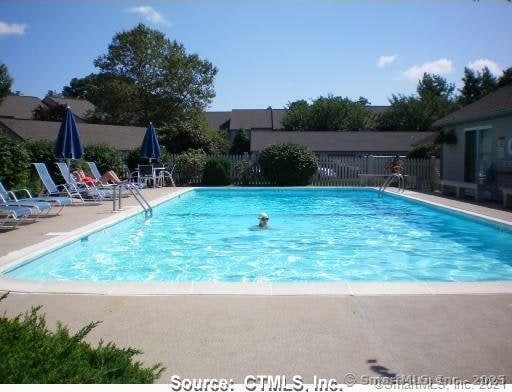 community pool featuring a patio and fence