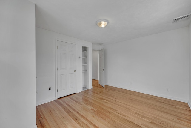 unfurnished bedroom featuring visible vents, light wood-type flooring, and baseboards