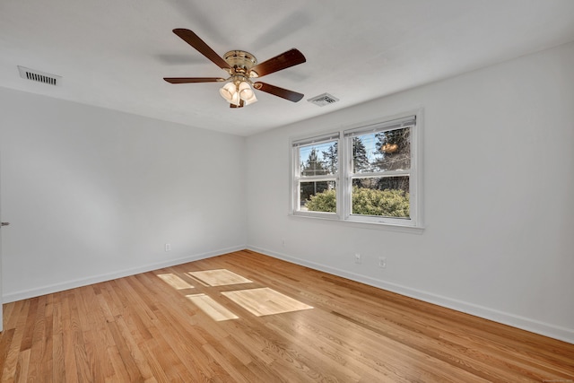 spare room featuring ceiling fan, visible vents, baseboards, and light wood-style flooring