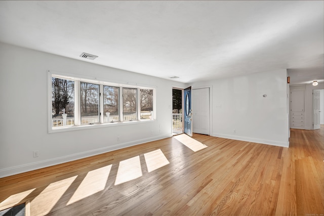 unfurnished living room with visible vents, baseboards, and light wood-style flooring