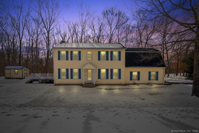 colonial-style house with a storage shed and an outbuilding