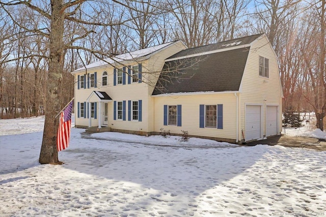 view of front facade with a garage, roof with shingles, and a gambrel roof