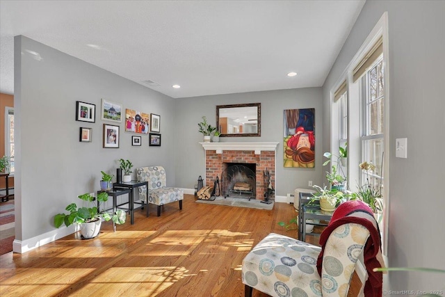 living room with recessed lighting, a fireplace, wood finished floors, and baseboards