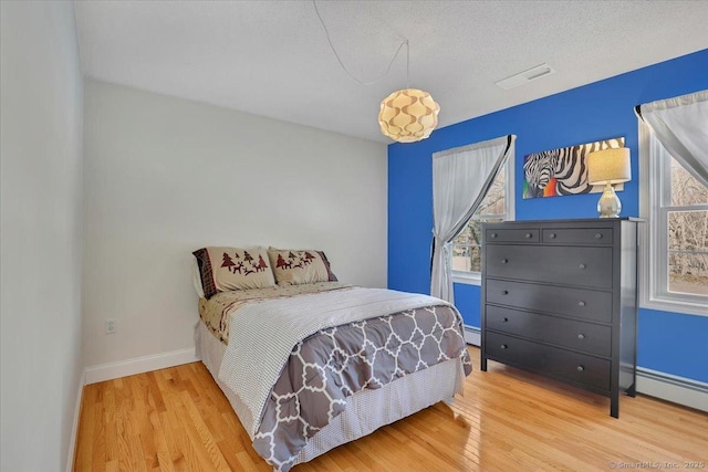 bedroom featuring wood finished floors, visible vents, and baseboards